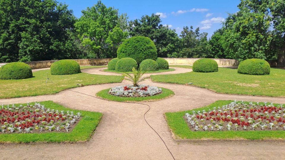 Nově zpřístupněné francouzské zahrady s květinovými záhony a jezírkem