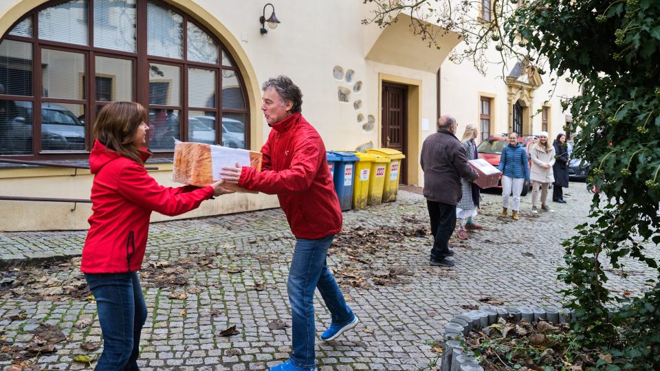 Pracovníci Arcidiecézní charita Olomouc přepravují do kamionu vánoční dárky od dobrovolníků