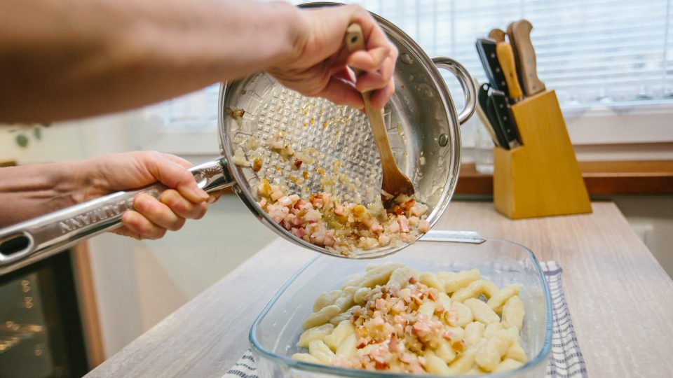 Vrstva zelných šlíšků se posype rozškvařenou slaninou s cibulí