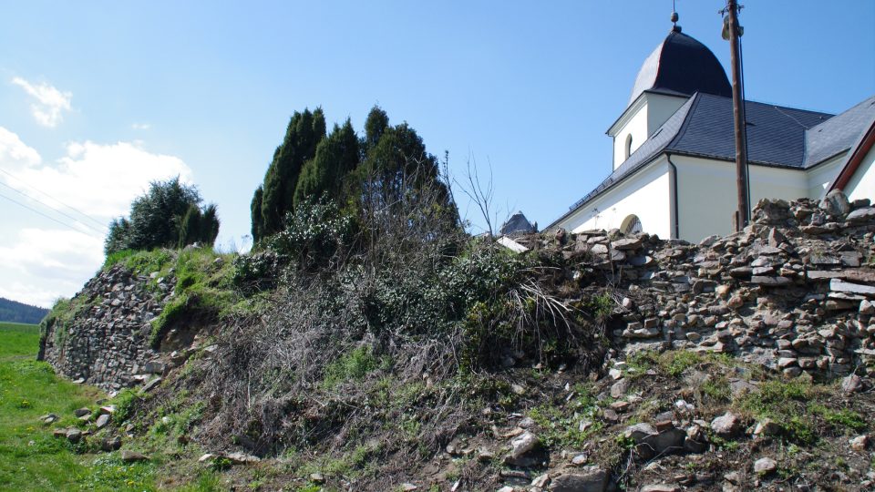 Zbytek hradby někdejšího opevněného kostela dodnes tvoří hřbitovní zeď