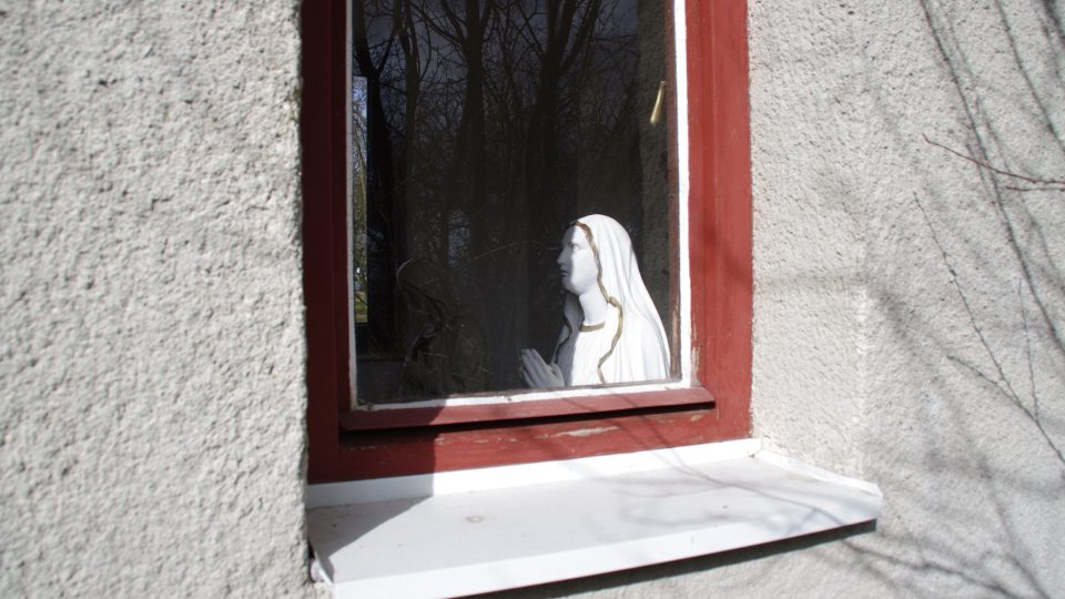 Mariánská socha vás sleduje oknem