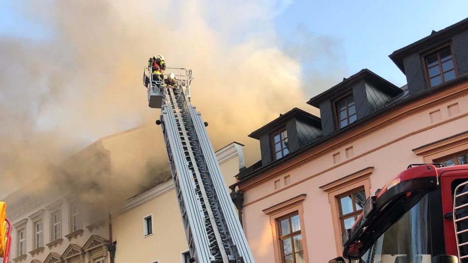 Oheň se rozšířil z bytové části domu do střechy i do dalších pater