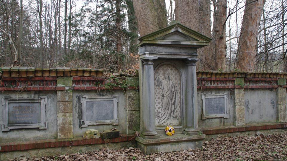 Hrobka někdejších majitelů zámku na hřbitově a za ní torzo někdejšího zámeckého parku